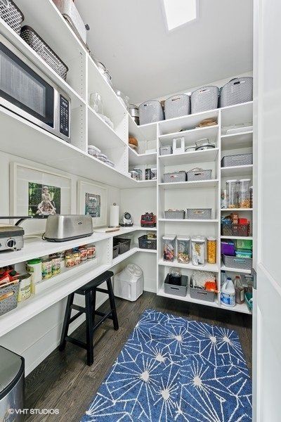 A pantry with lots of shelves and a blue rug