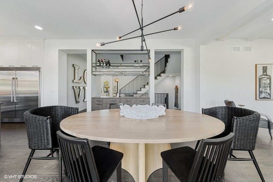 A dining room with a round table and chairs and a chandelier.
