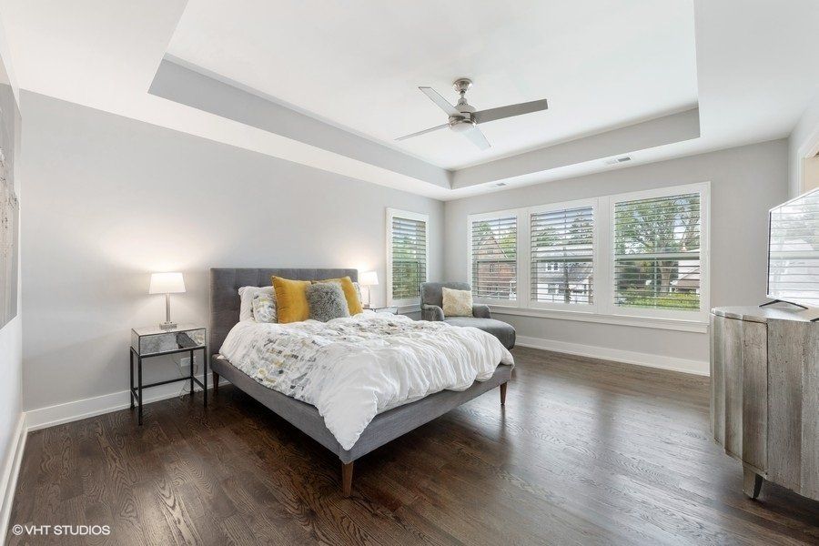 A bedroom with a large bed and a ceiling fan.