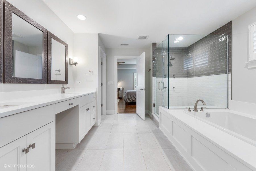 A bathroom with white cabinets and a bathtub