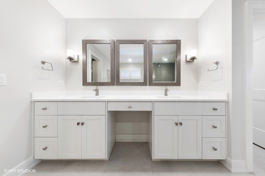 A bathroom with two sinks and three mirrors.