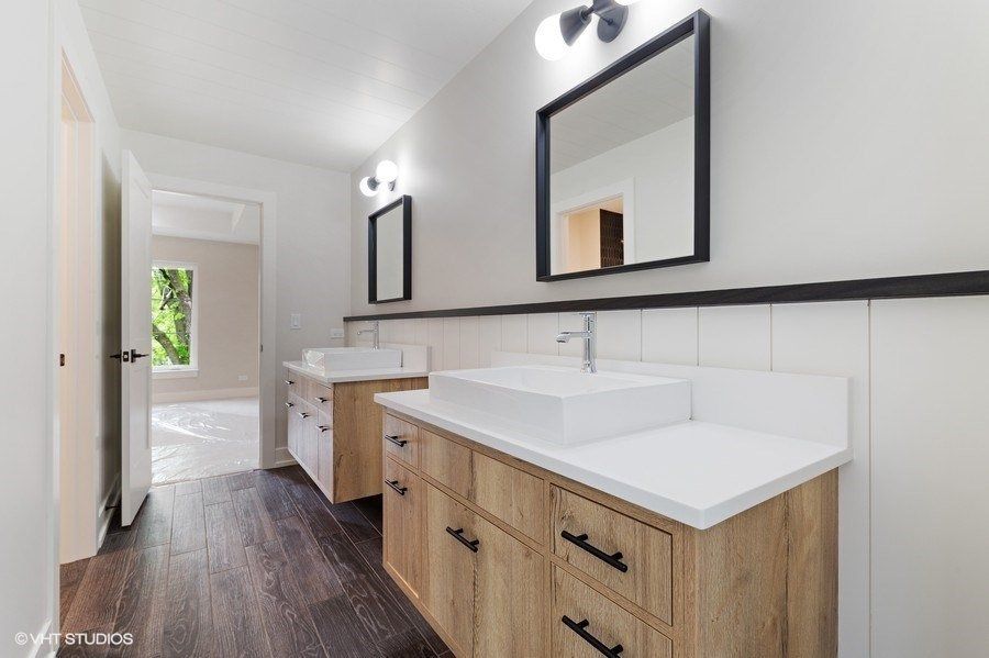 A bathroom with two sinks and two mirrors.