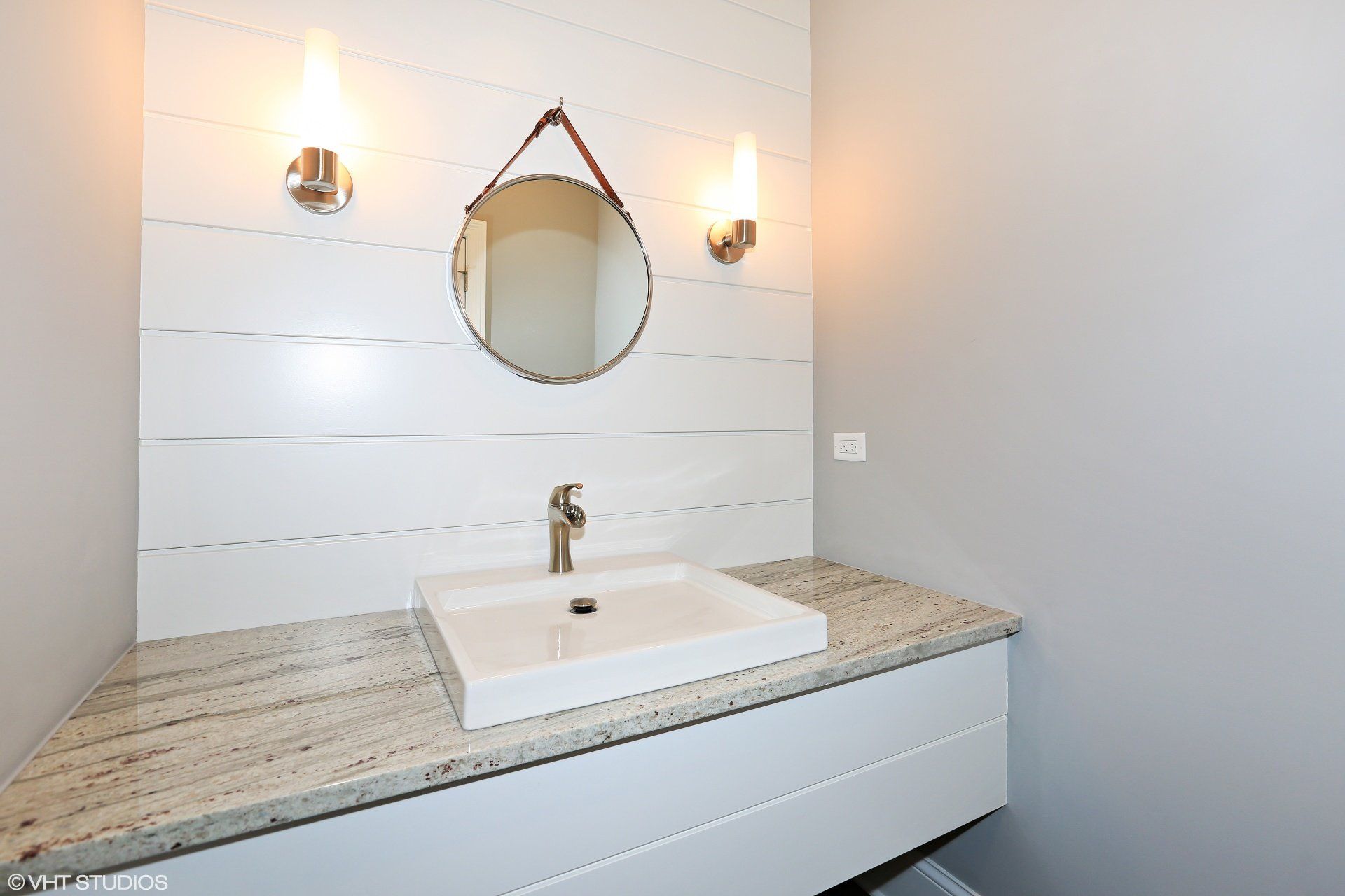 A bathroom with a sink and a mirror on the wall.