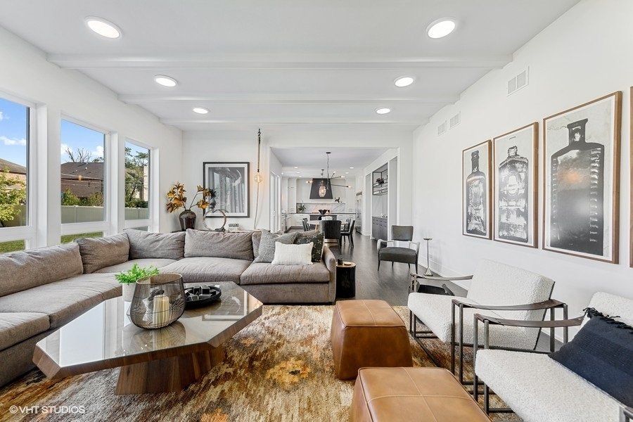 A living room with a couch , chairs , and a coffee table.