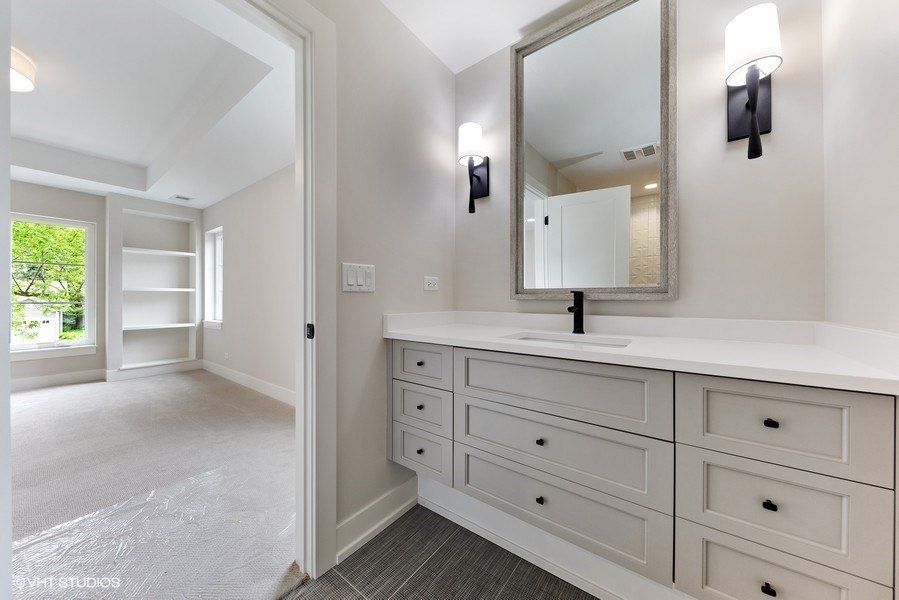 A bathroom with a sink , mirror and drawers