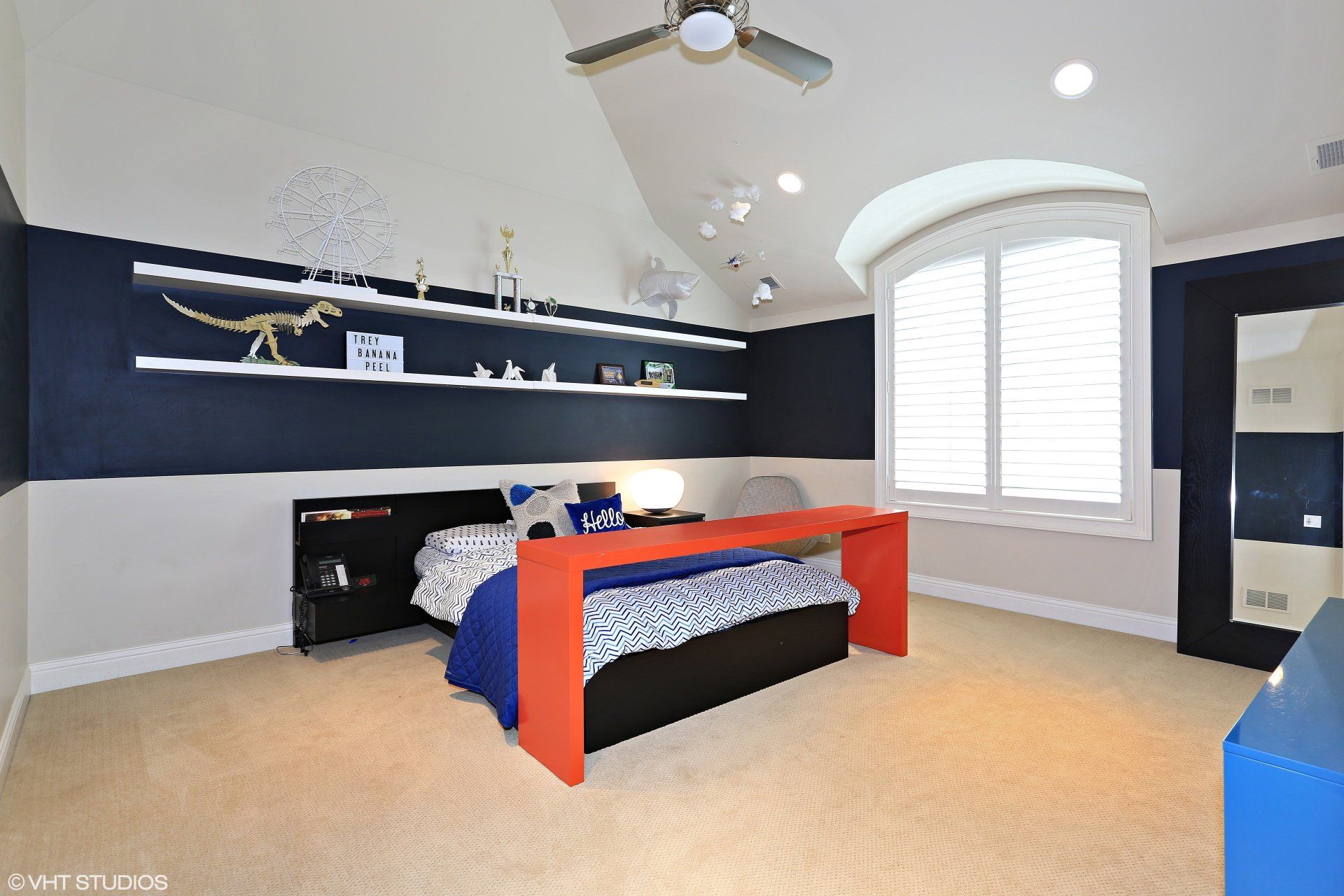 A bedroom with a bed and a ceiling fan