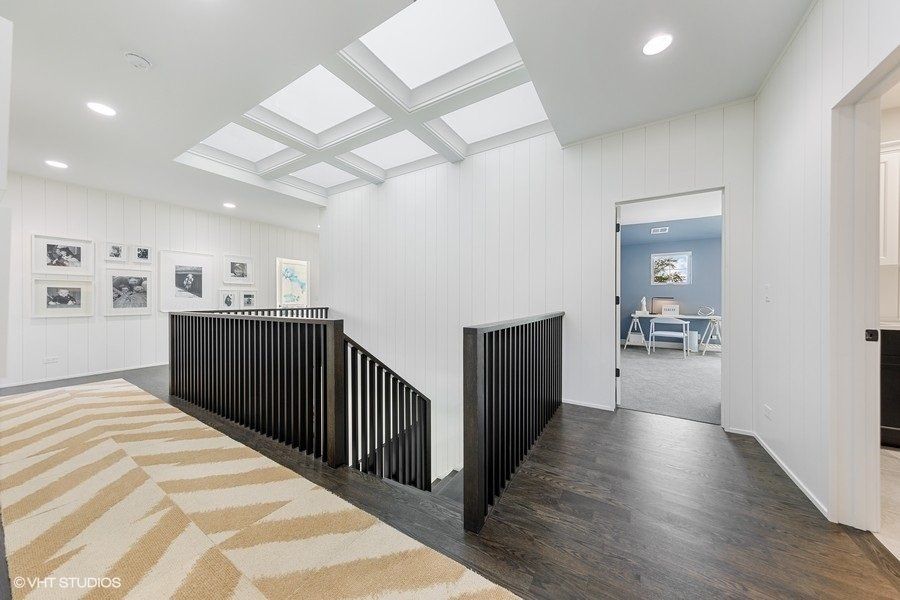 A hallway with a staircase leading up to the second floor of a house.