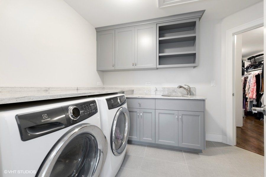 A laundry room with a washer and dryer and a sink
