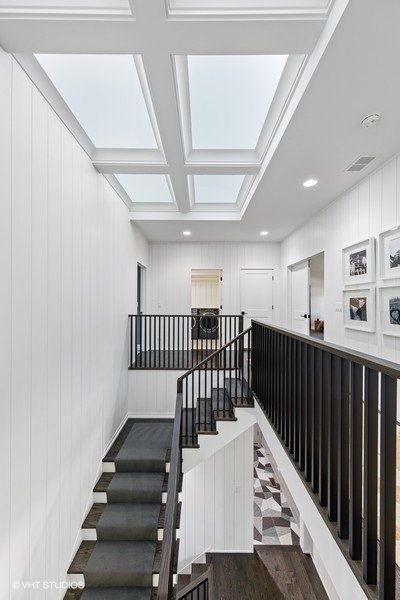 A staircase in a house with a skylight above it.
