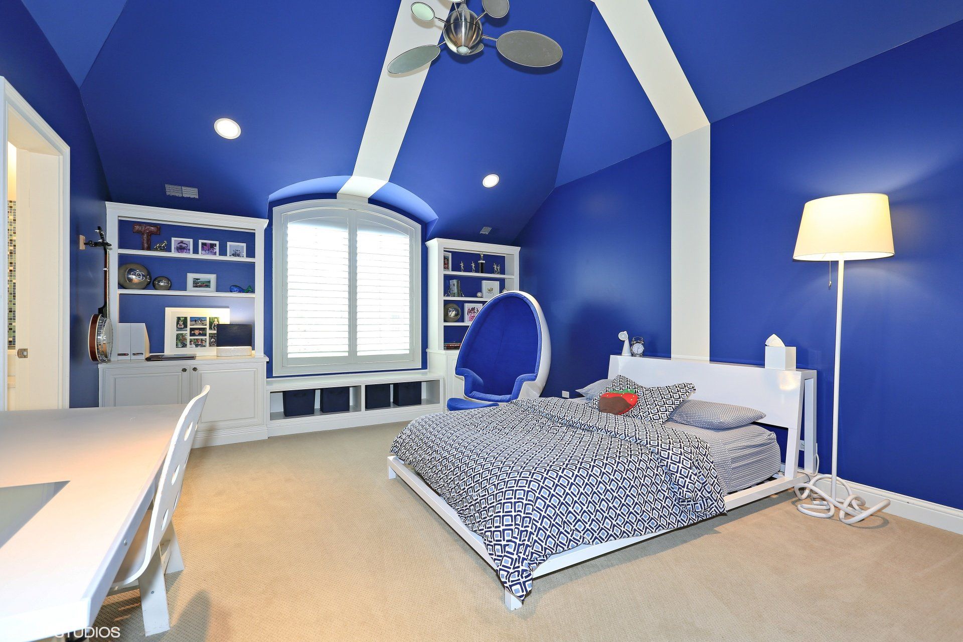 A bedroom with blue and white walls and a bed