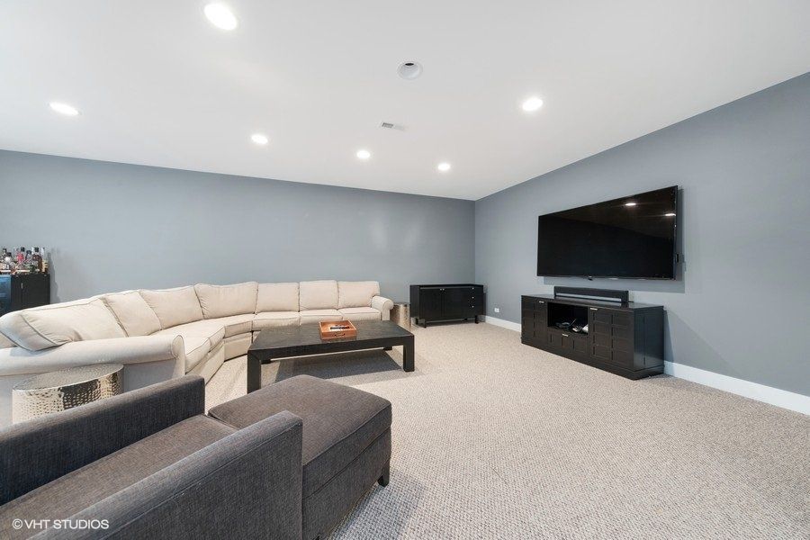 A living room with a large sectional couch and a flat screen tv.