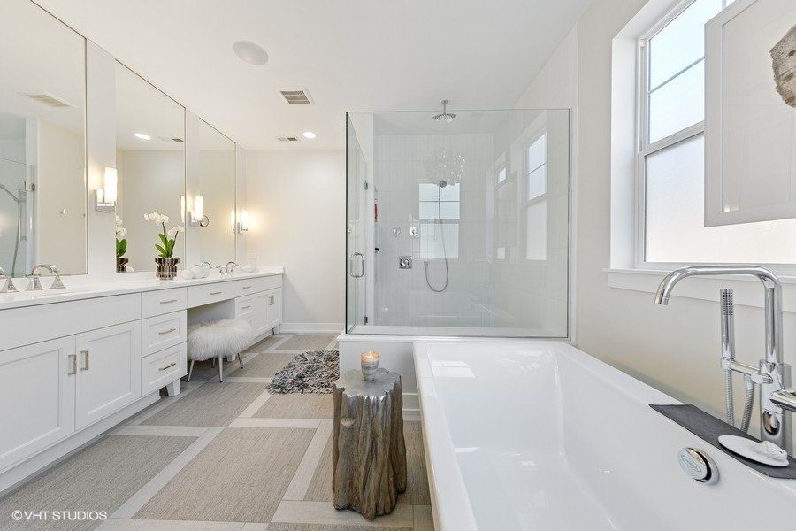 A bathroom with two sinks , a tub and a shower.