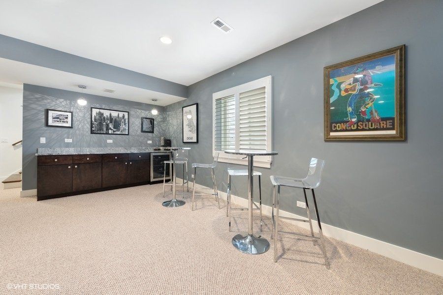 A basement with a table and chairs and a painting on the wall.