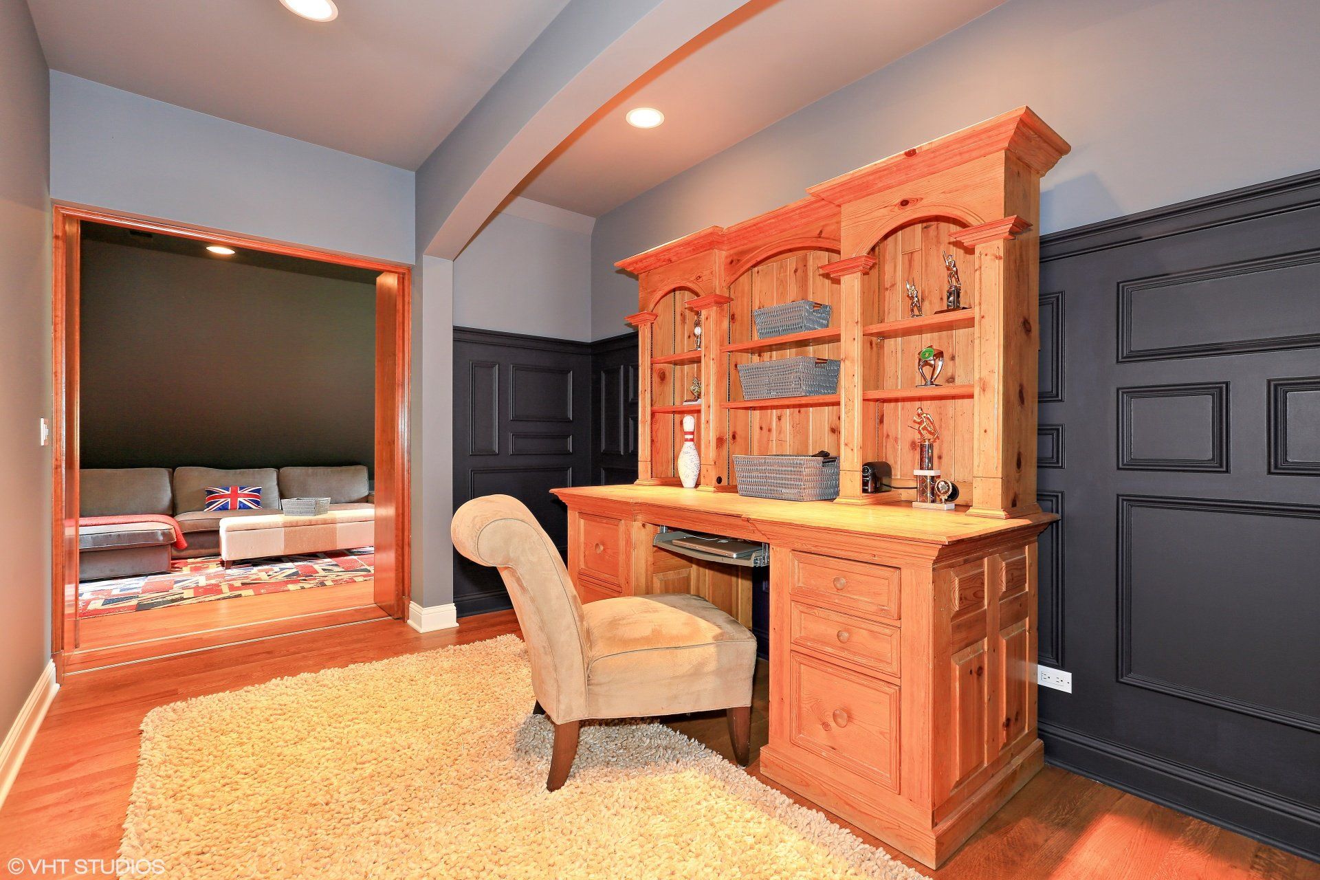 A wooden desk with a chair in a living room