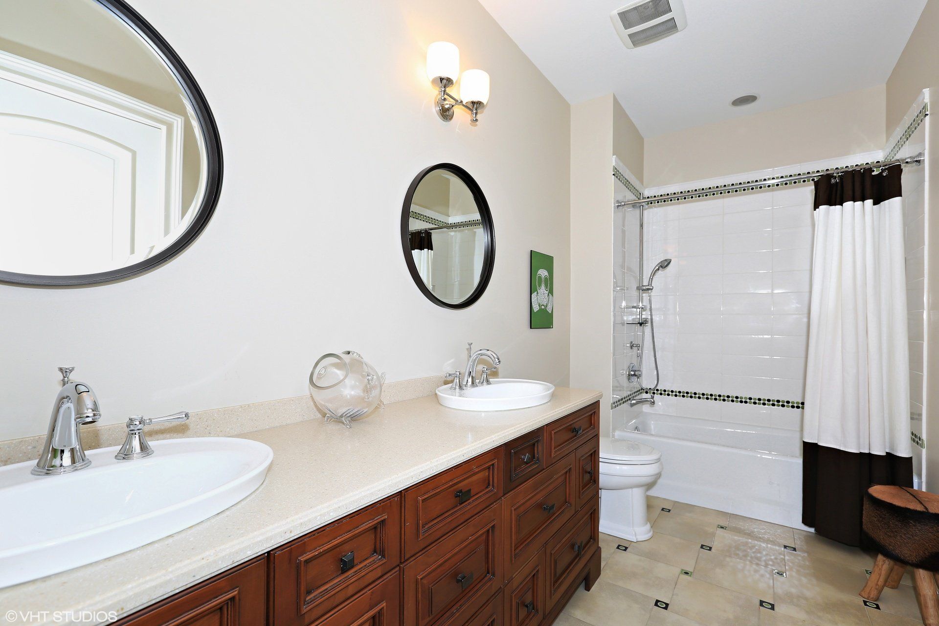 A bathroom with two sinks , a toilet , and a shower.