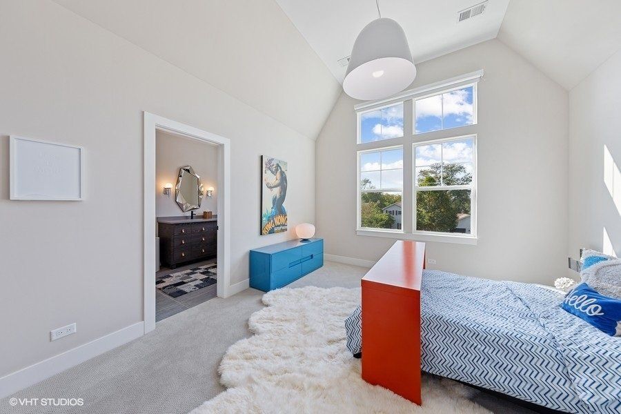 A bedroom with a bed a dresser and a window