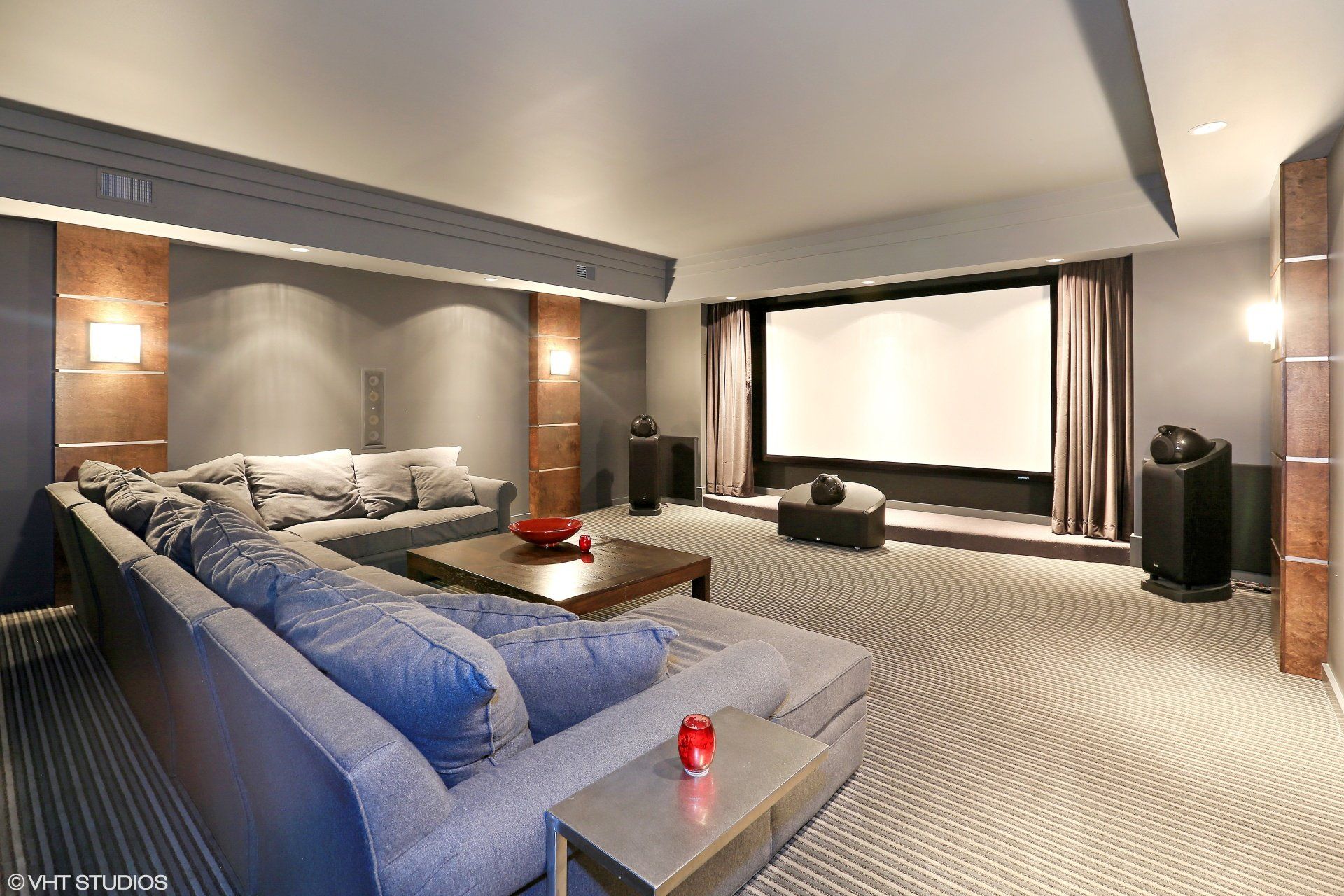 A home theater with a large couch and a large screen