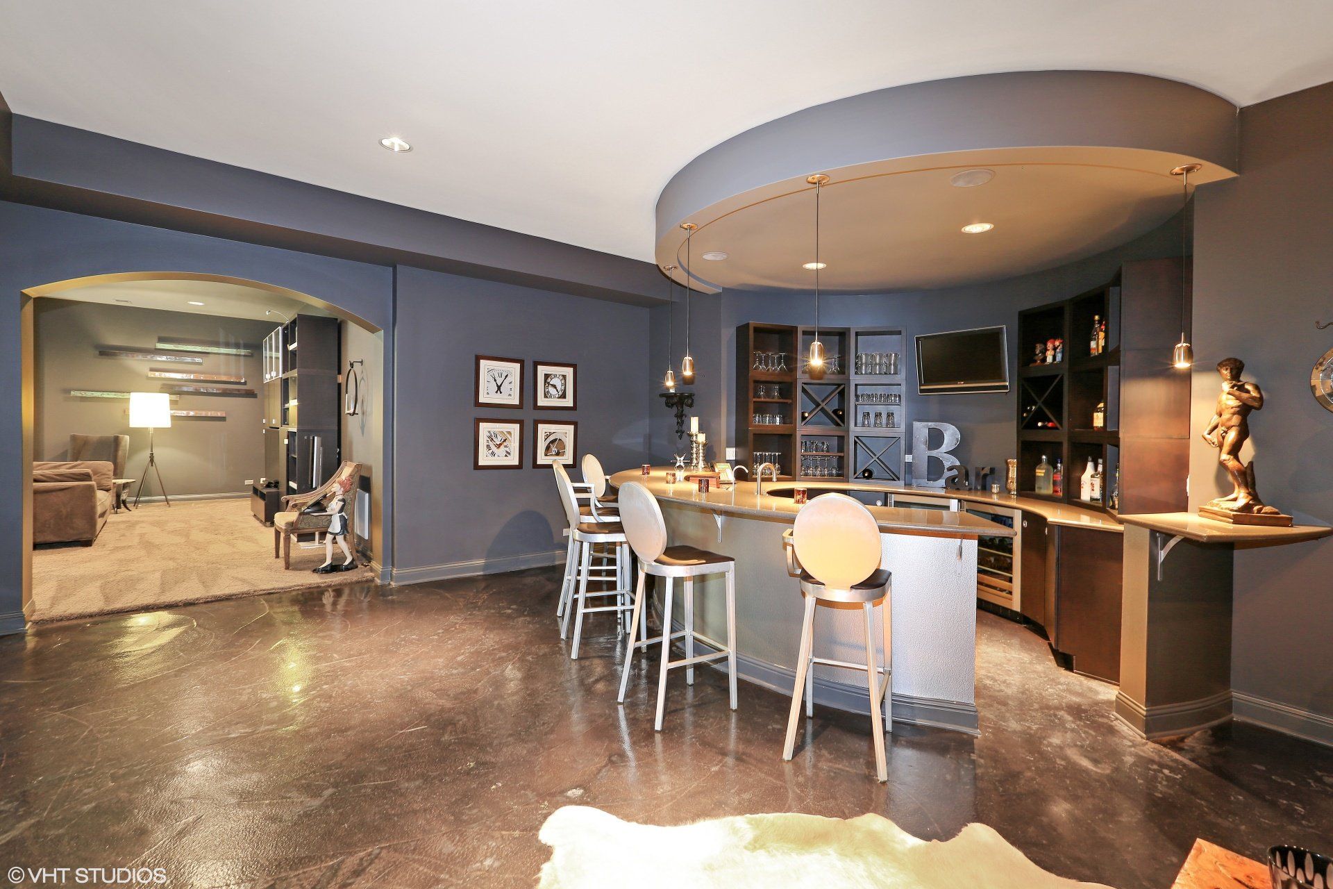 A large room with a bar and chairs in it