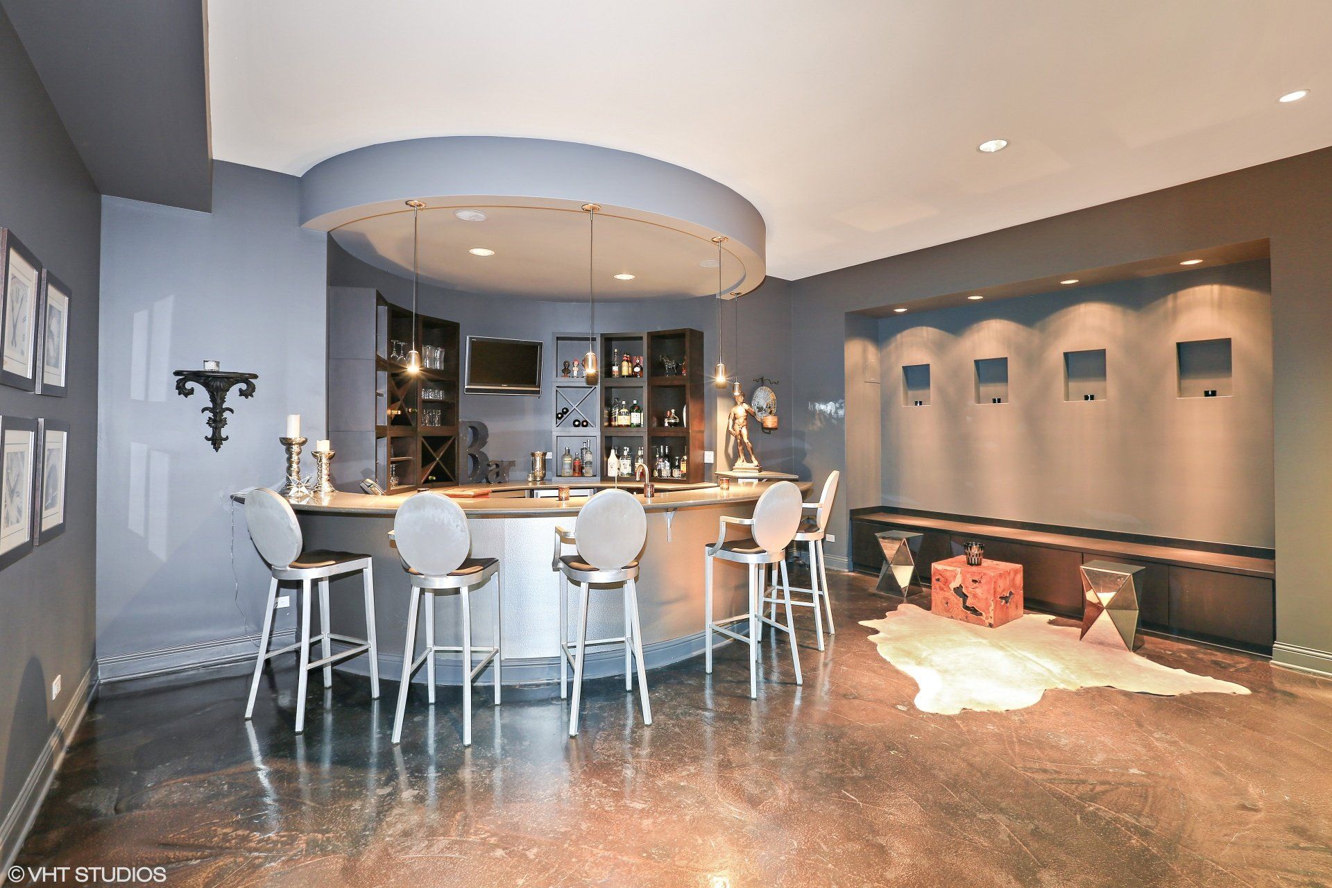 A large room with a bar and stools in it