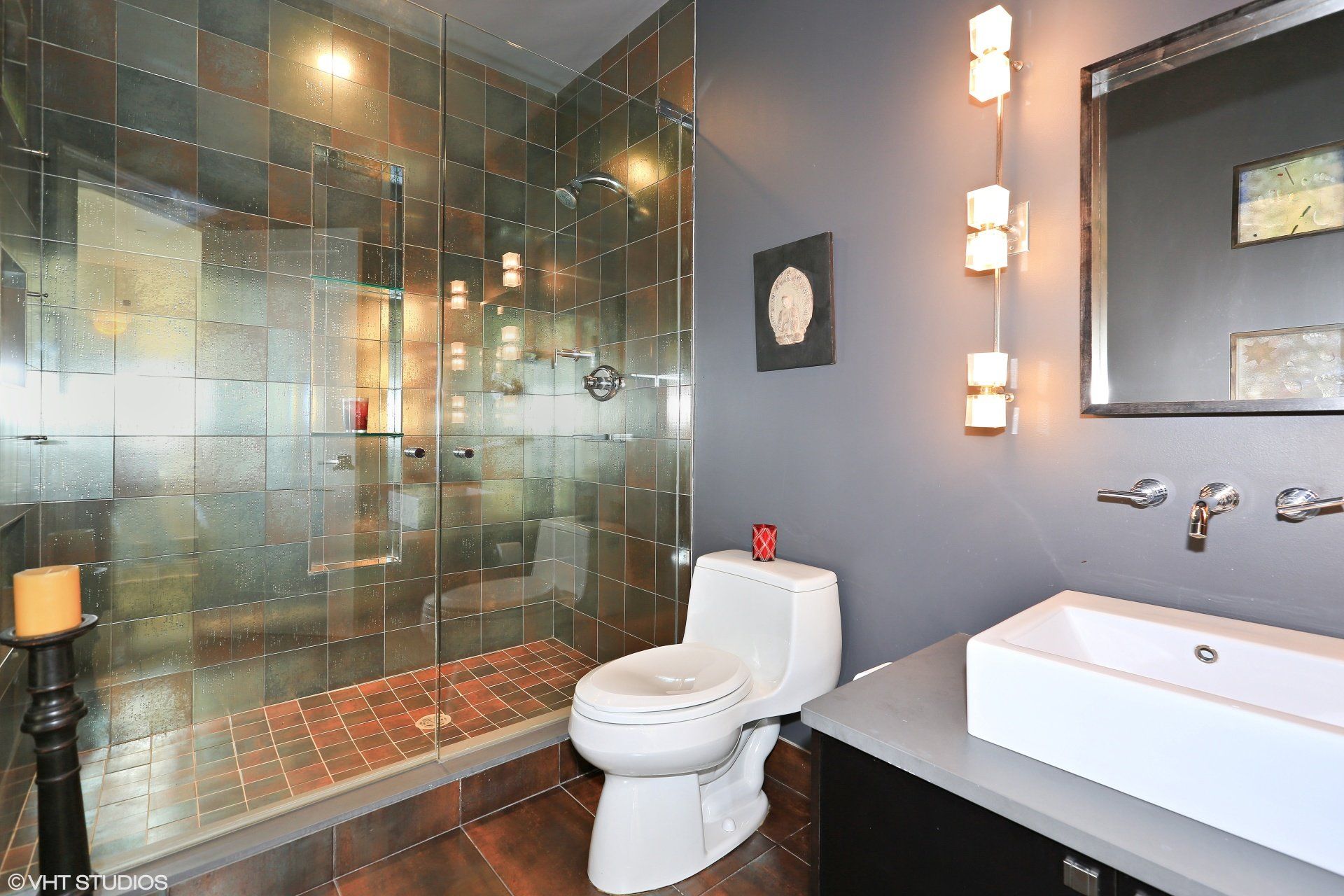 A bathroom with a toilet , sink and walk in shower