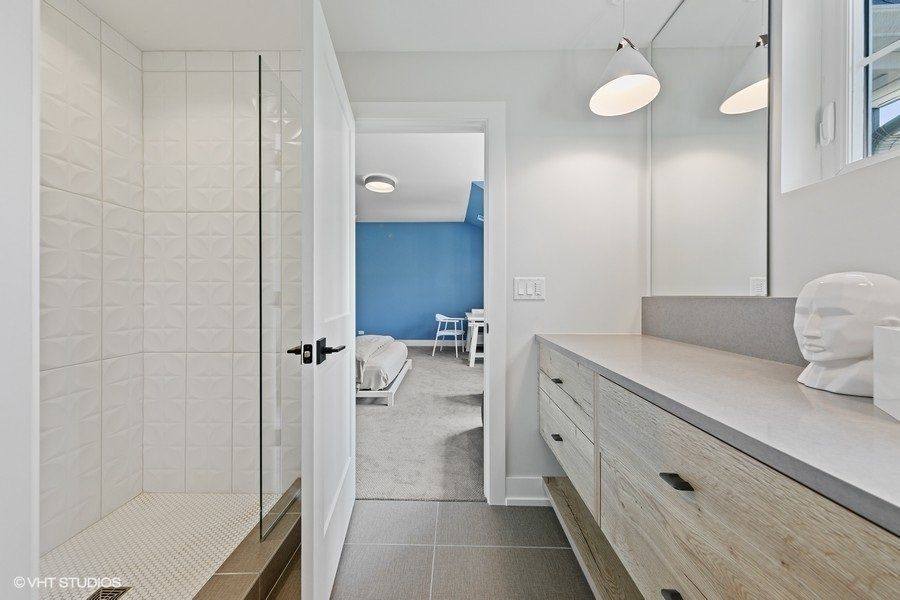 A bathroom with a walk in shower and a vanity.