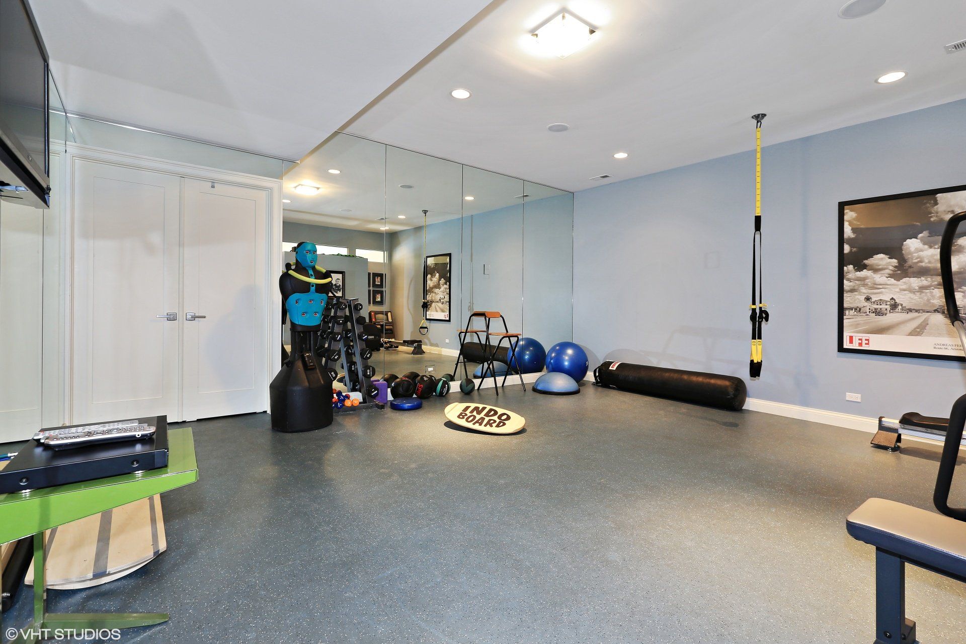 A gym with a lot of equipment and a large mirror