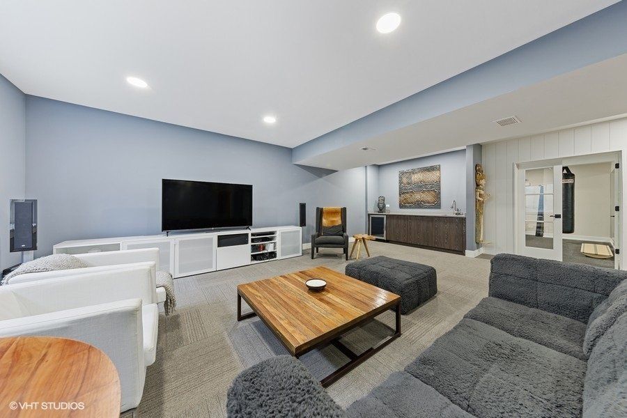 A living room with a couch , chairs , coffee table and television.