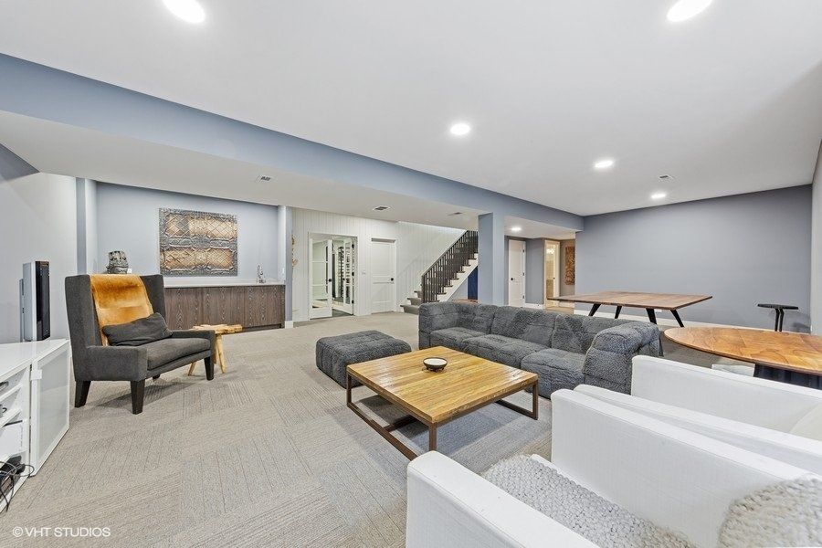 A living room with a couch , chairs , coffee table and ping pong table.