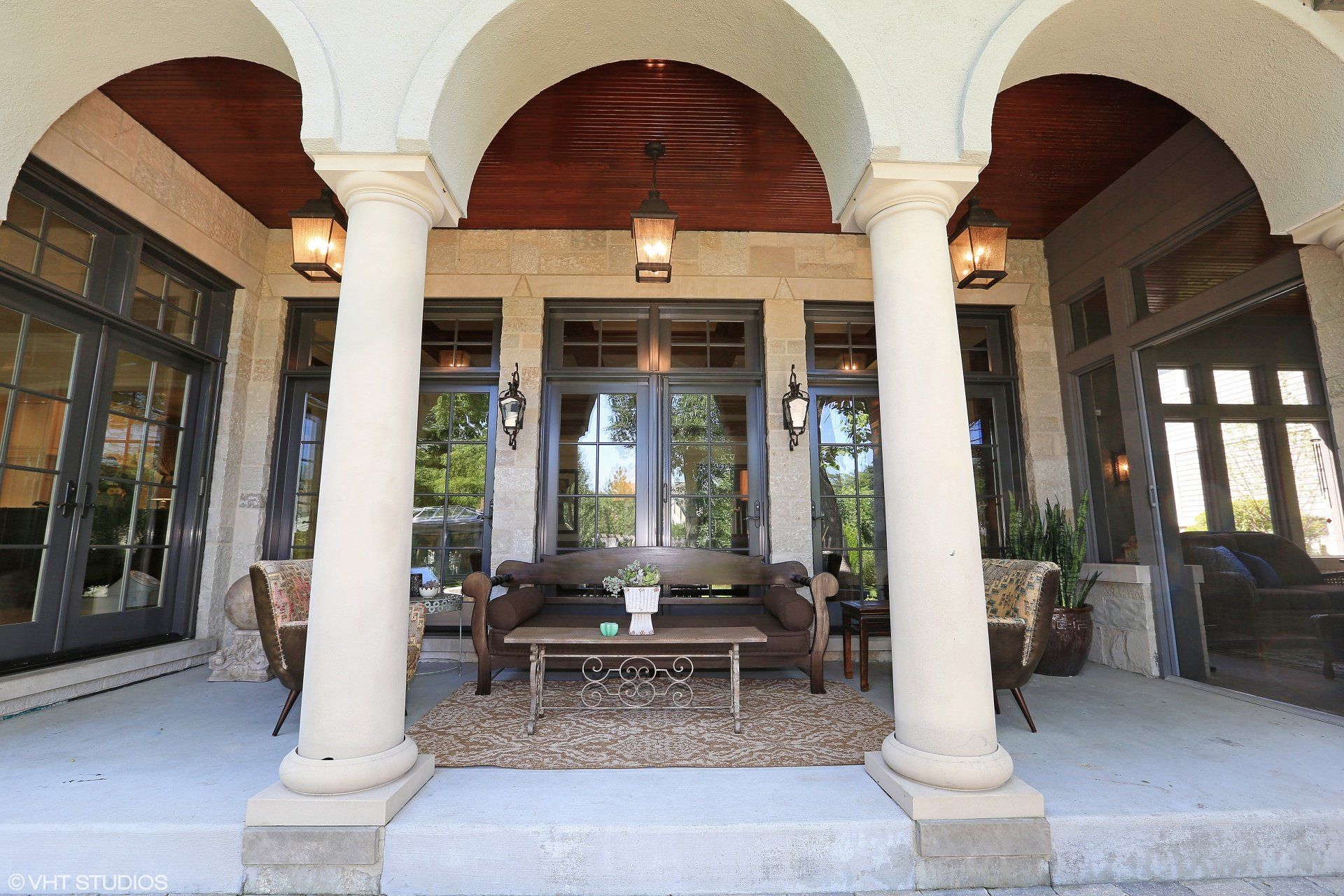 The front porch of a house with columns and arches
