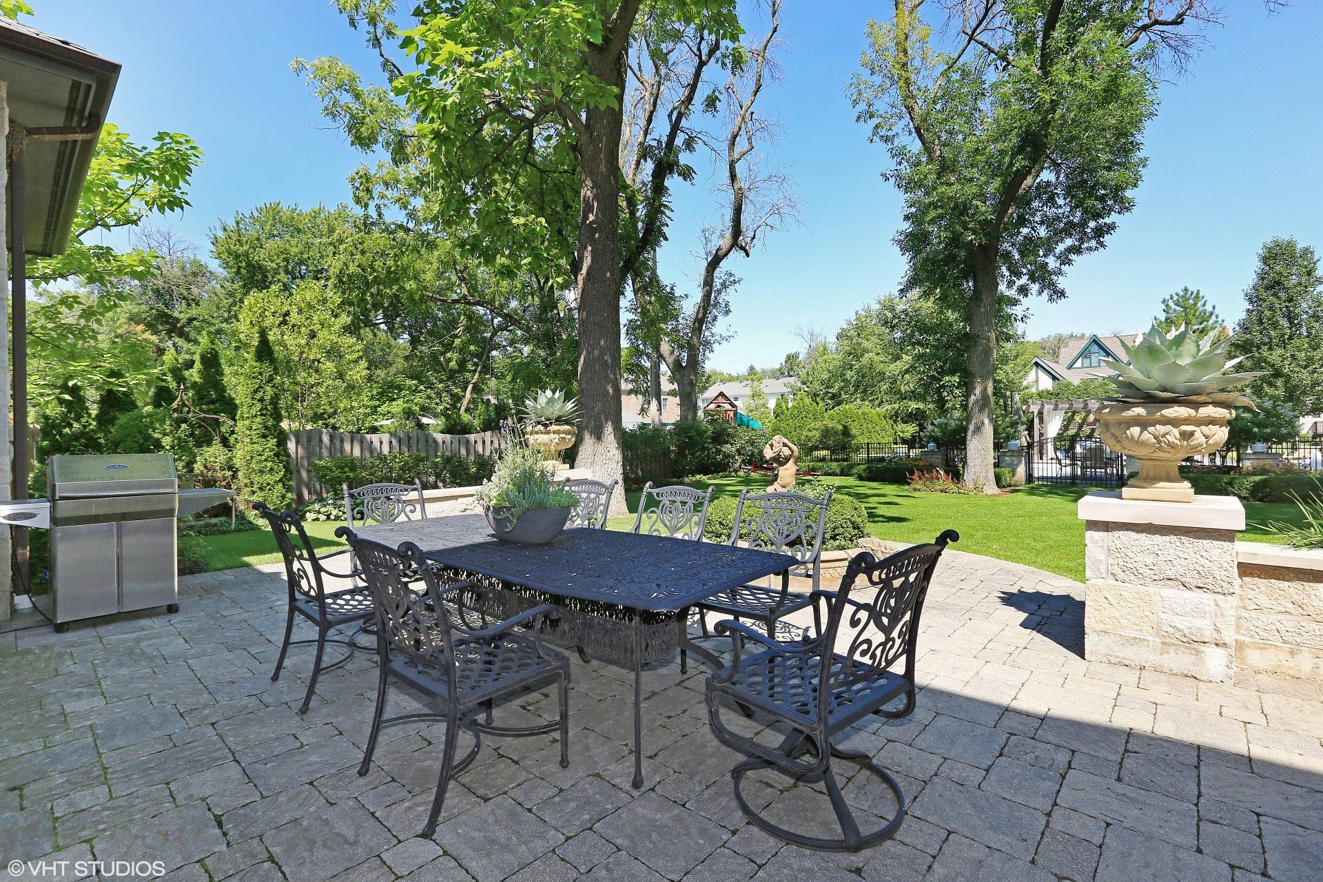 A patio with a table and chairs and a grill