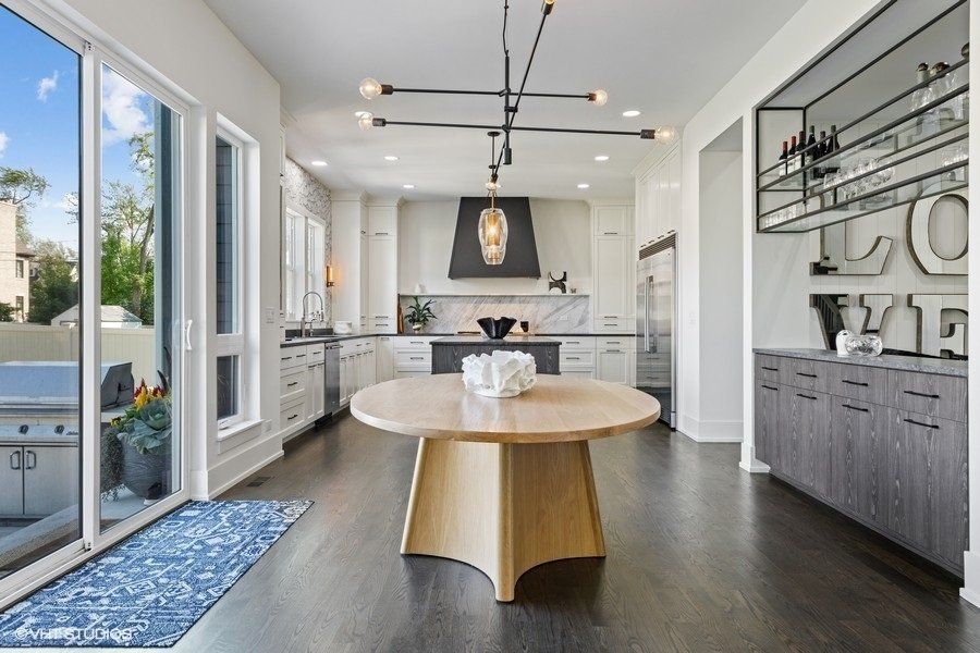 A kitchen with a round table and sliding glass doors