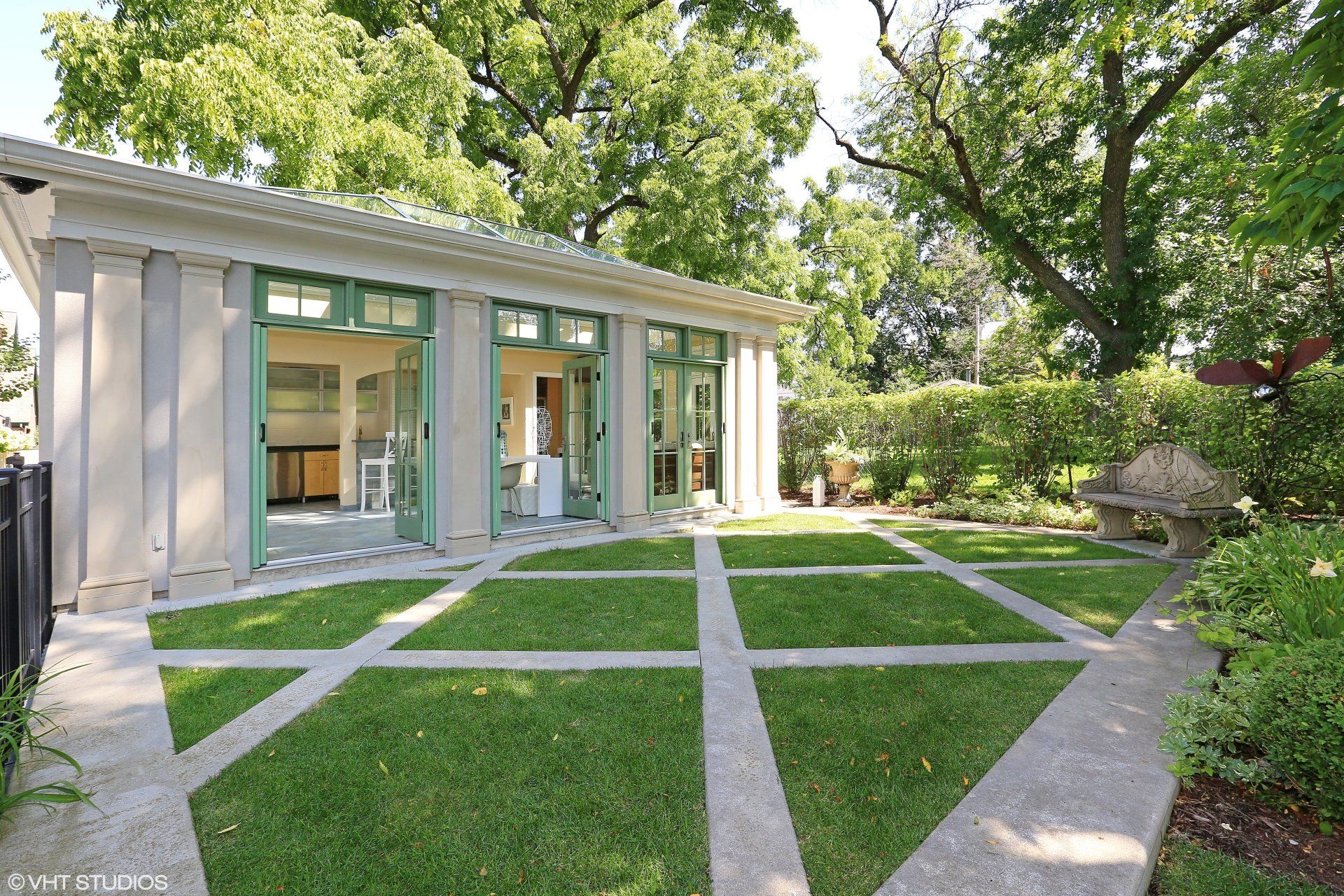 A house with a lot of windows and a lawn in front of it