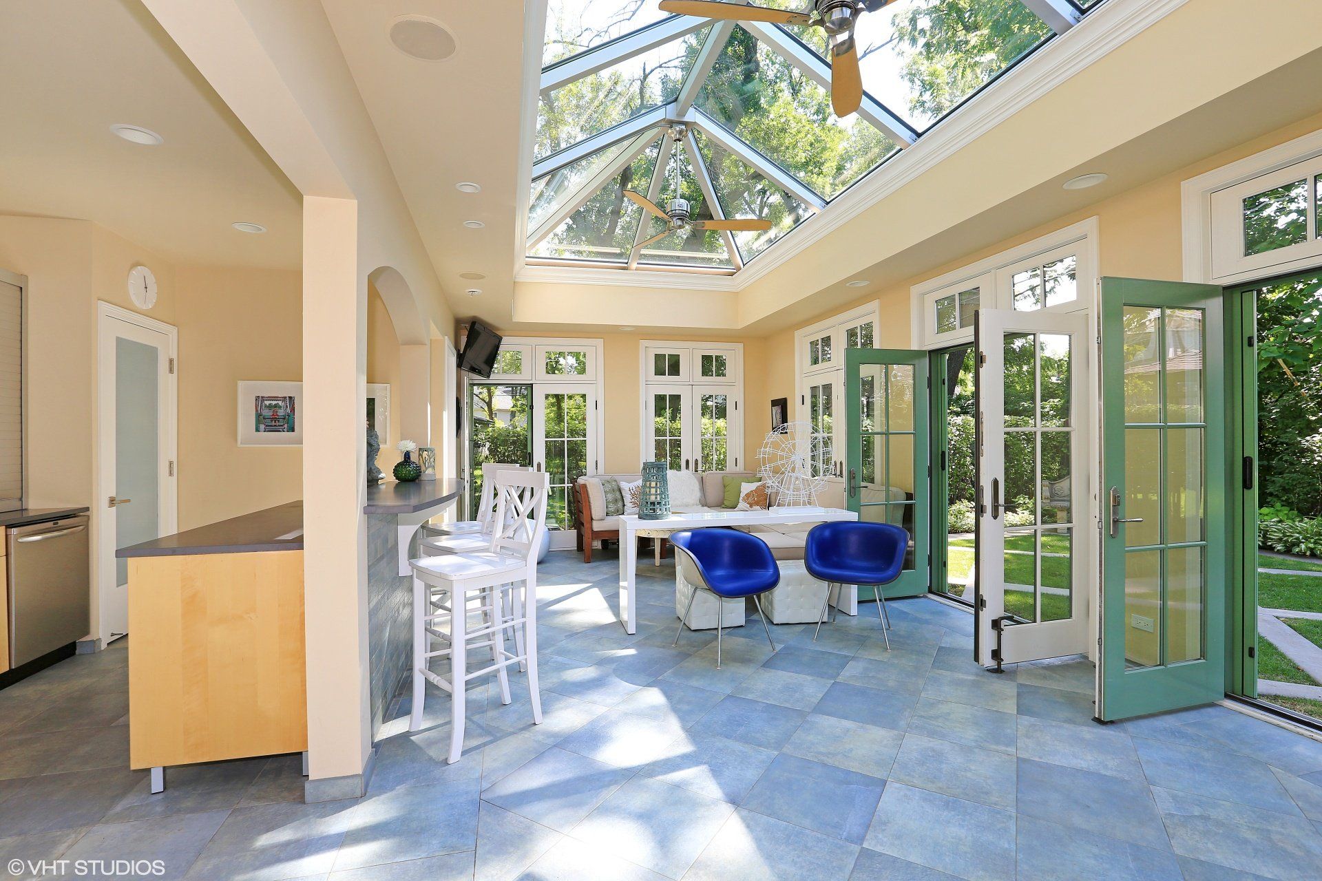A large room with a lot of windows and a ceiling fan.