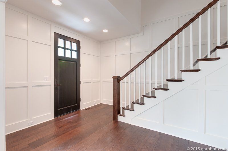 An empty hallway with a staircase and a door