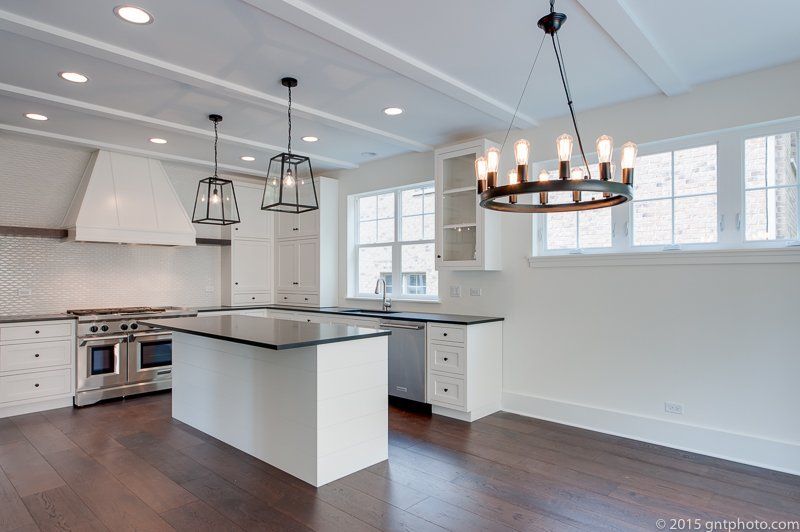 A kitchen with a large island and a chandelier hanging from the ceiling