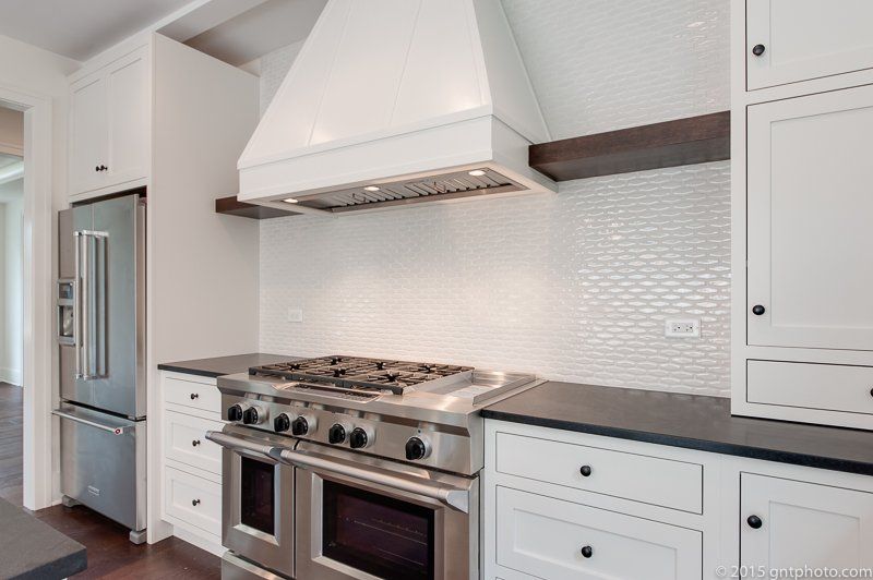 A kitchen with stainless steel appliances and white cabinets.