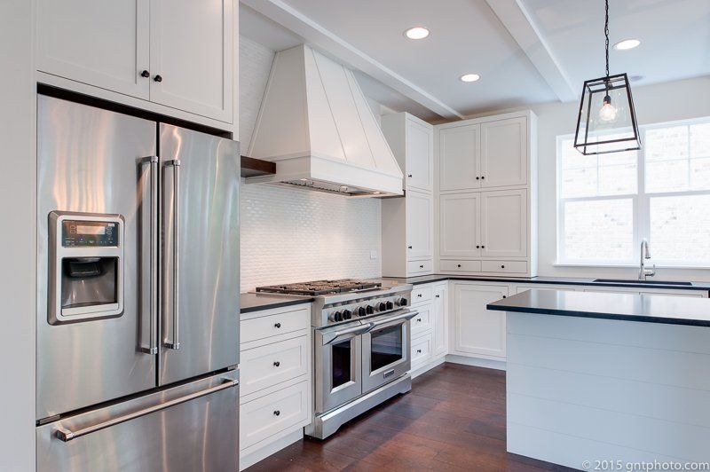 A kitchen with stainless steel appliances and white cabinets