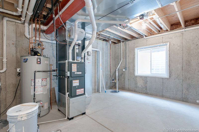 A basement with a water heater and a furnace.