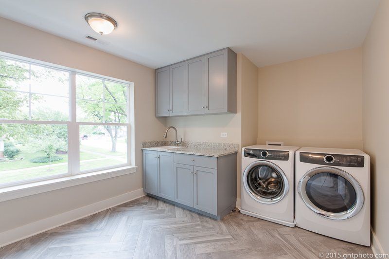 A laundry room with a washer and dryer and a sink.