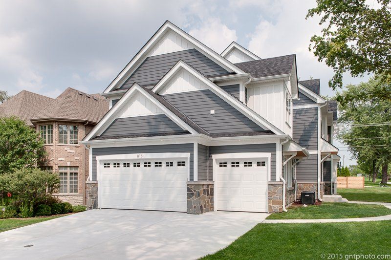 A large house with two garage doors and a driveway