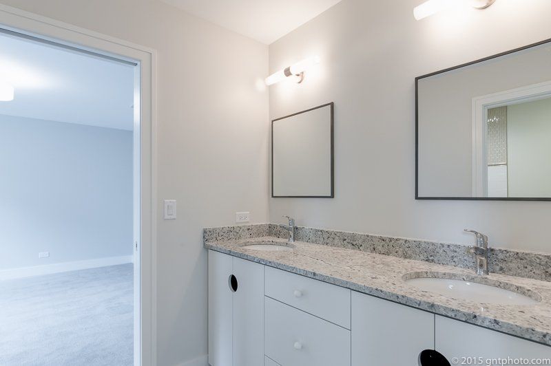 A bathroom with two sinks and a mirror.