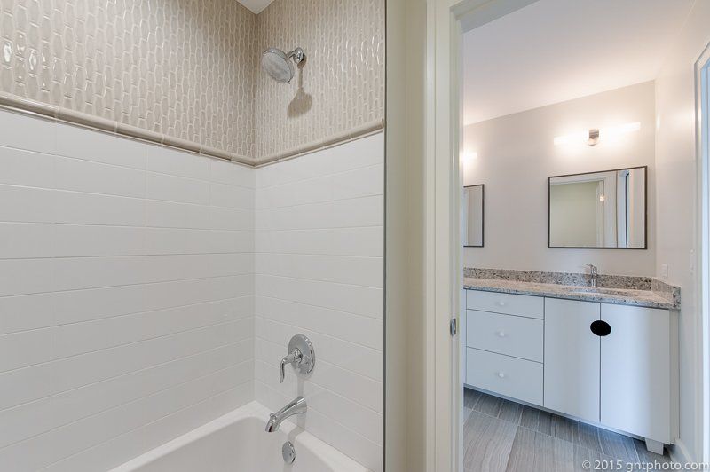 A bathroom with a bathtub , shower , sink and mirror.