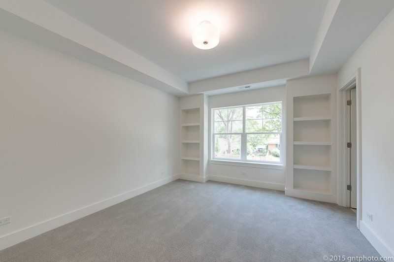 An empty room with a window and shelves in it.