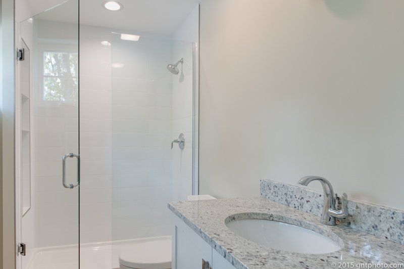 A bathroom with a sink and a walk in shower.