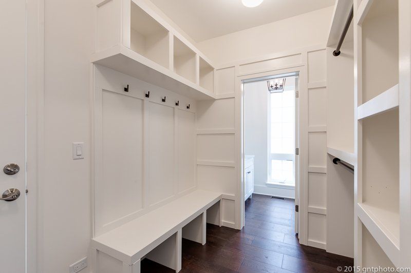 A walk in closet with a bench and shelves in a house.