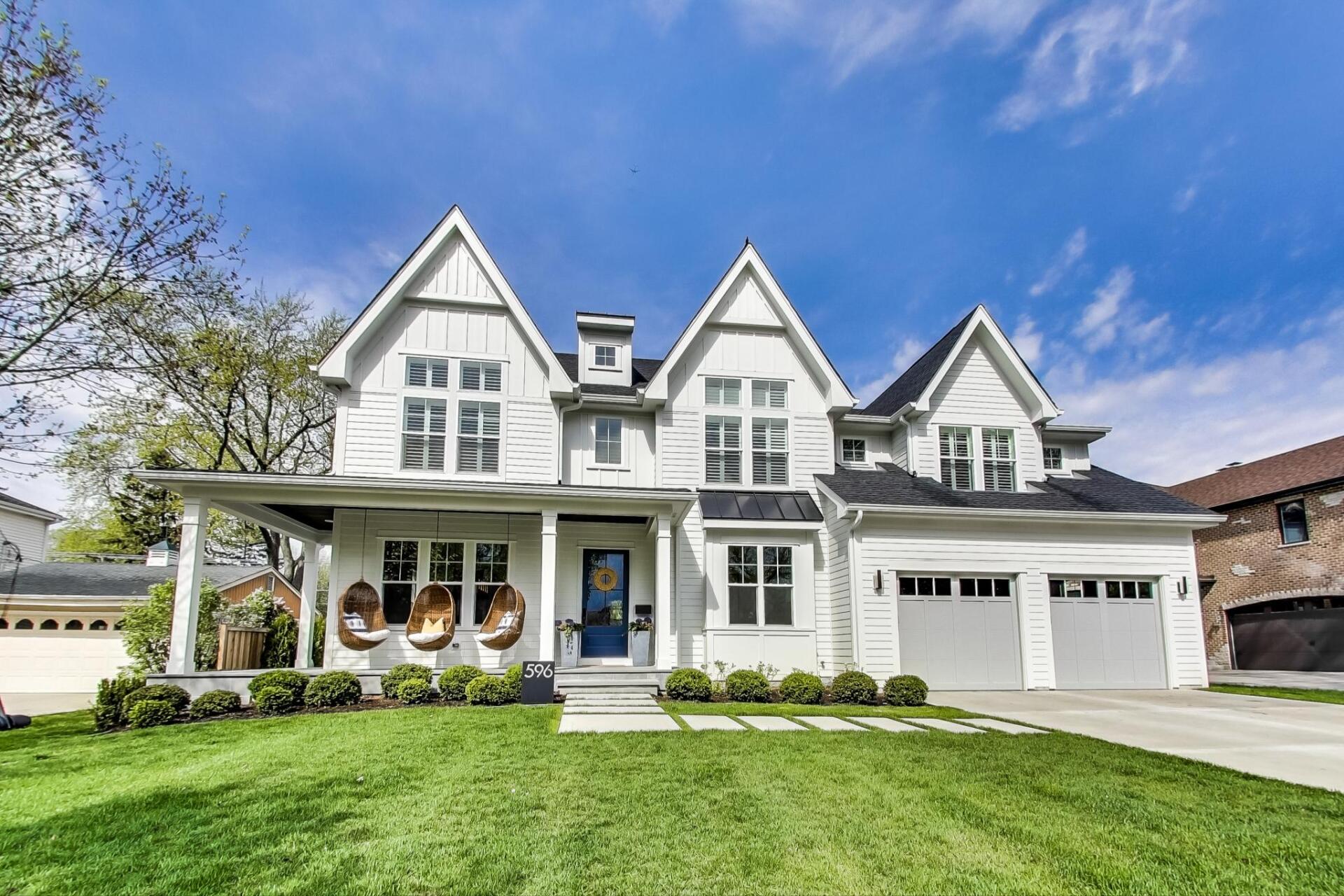 A large white house with a blue door and a porch.