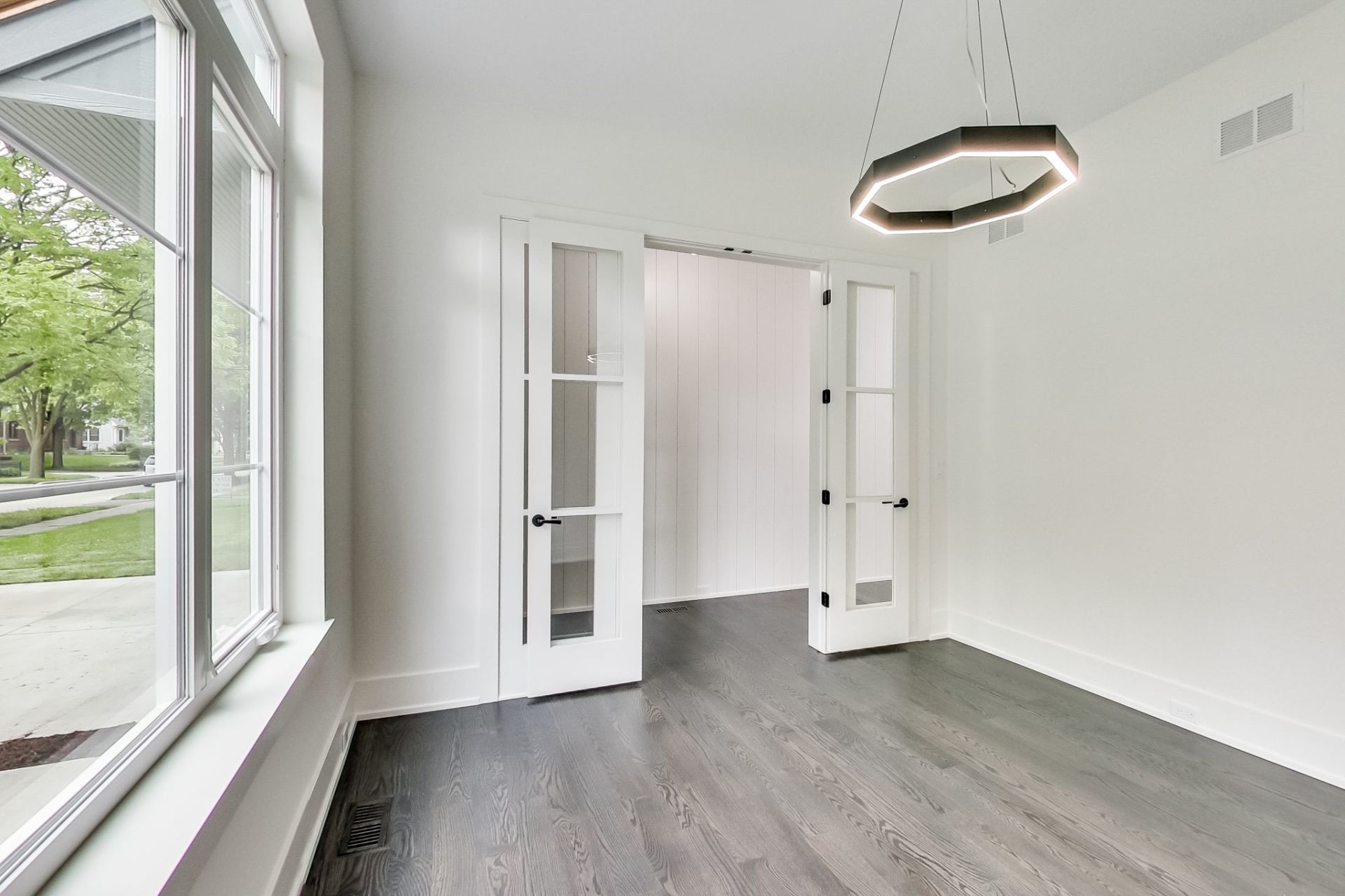 An empty room with hardwood floors and white walls