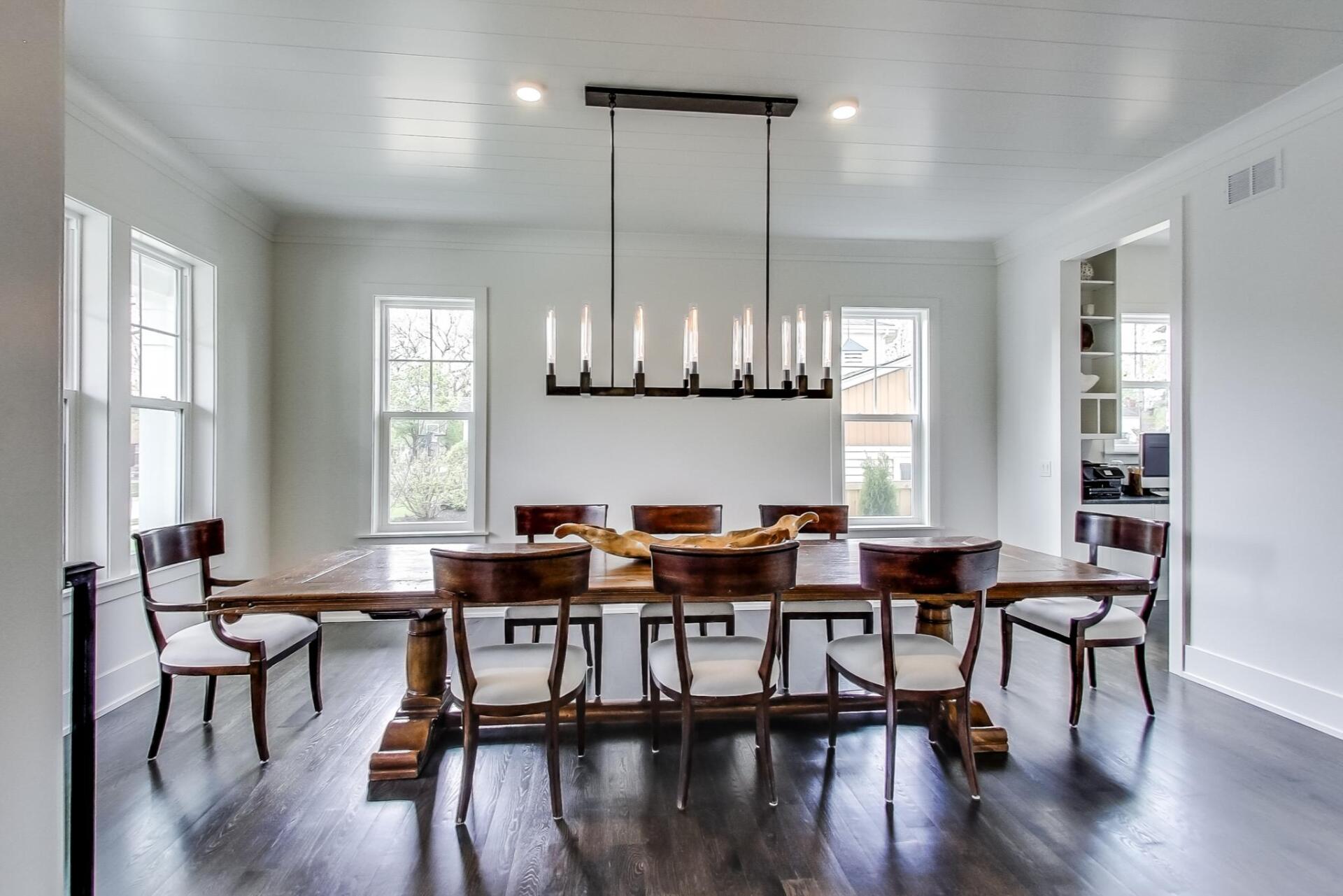 A dining room with a long wooden table and chairs