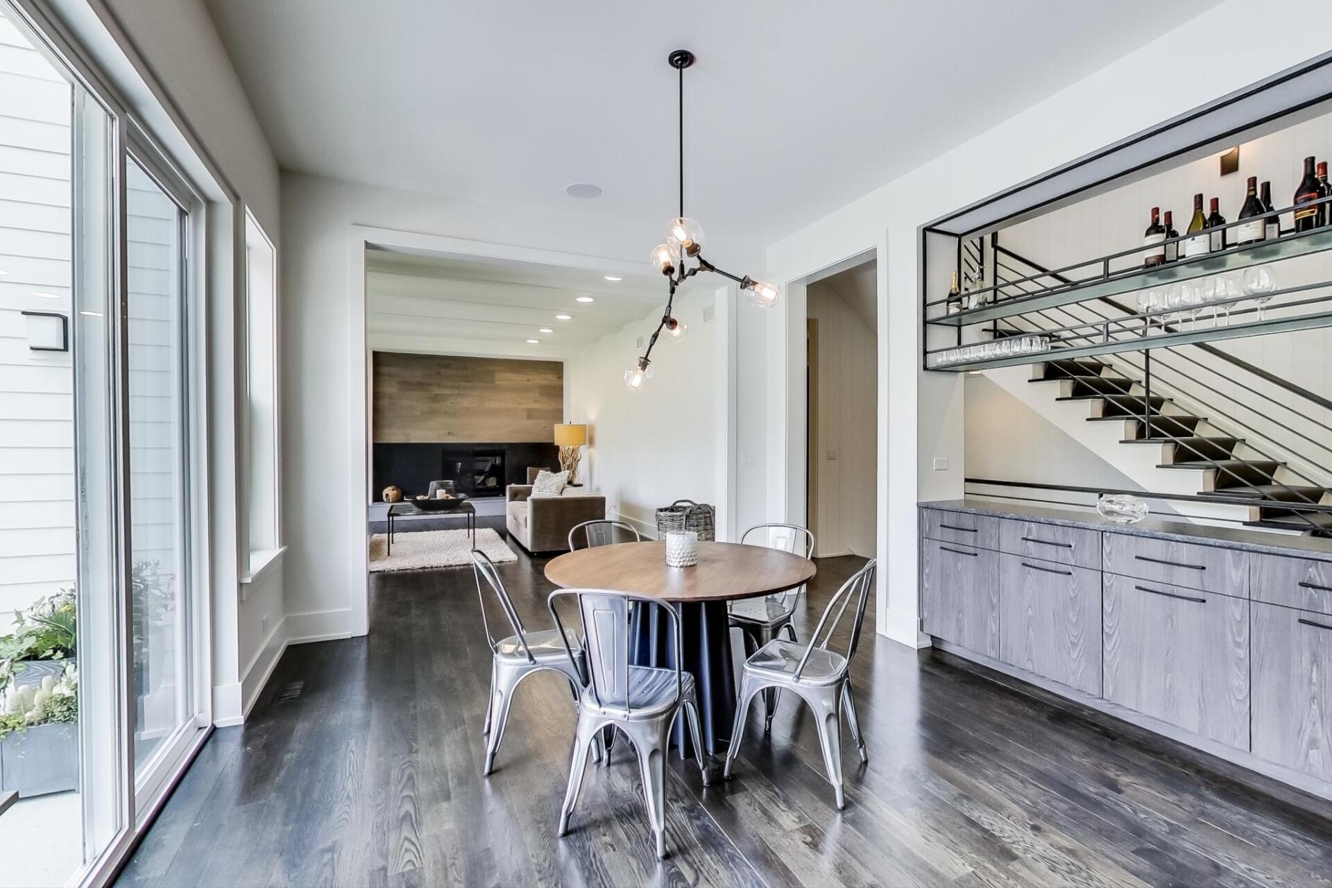 A dining room with a round table and chairs and a bar.