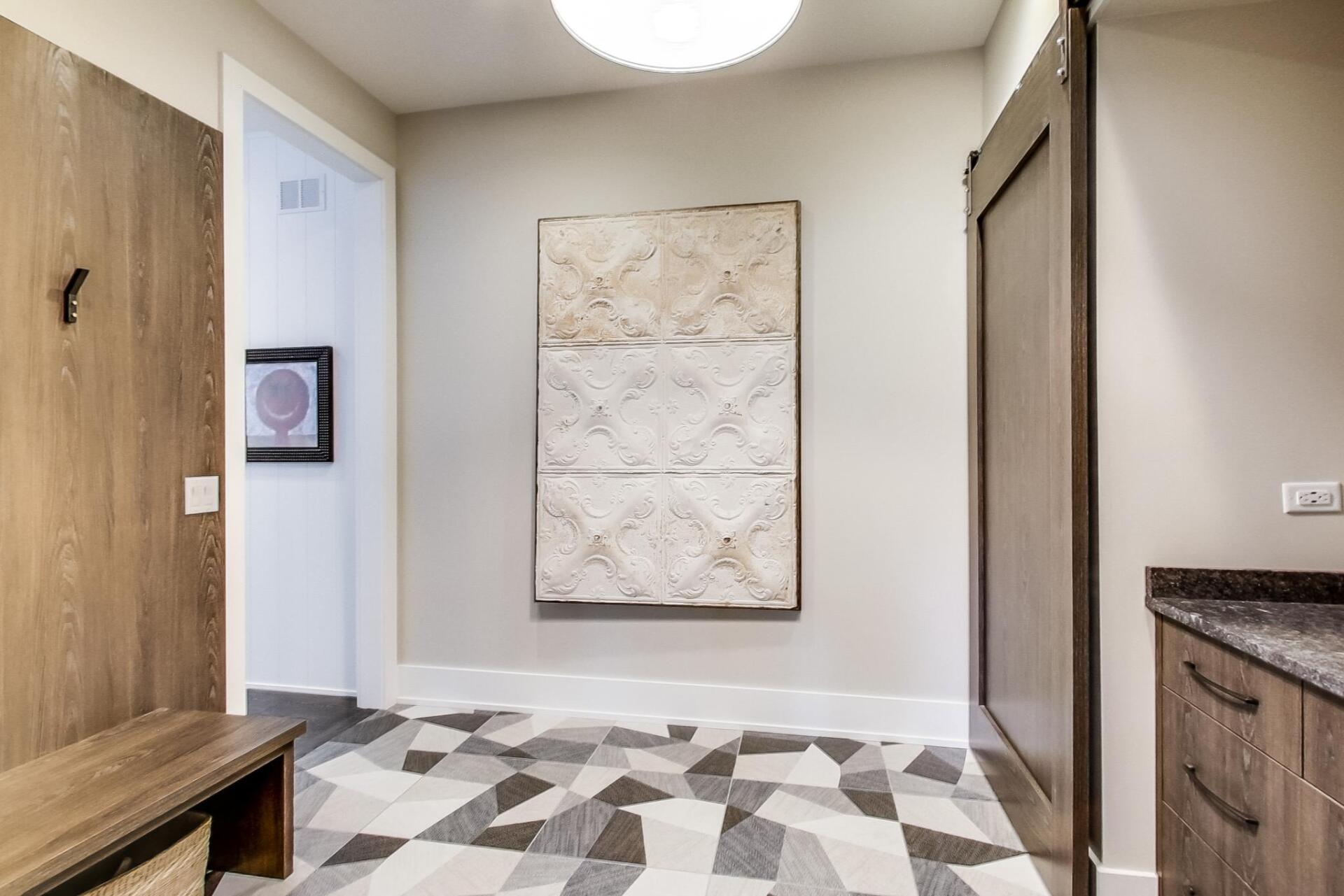 A hallway with a painting on the wall and a bench.